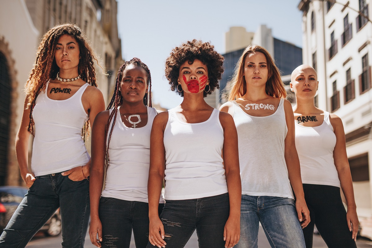 Image of five diverse women in white T-shorts looking straight ahead with a face that says I have had enough.