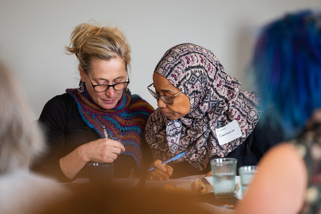 two women speaking one with a hijab