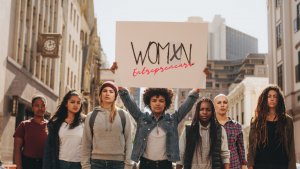 A photo of diverse women holding up a sign that says womxn entrepreneurs