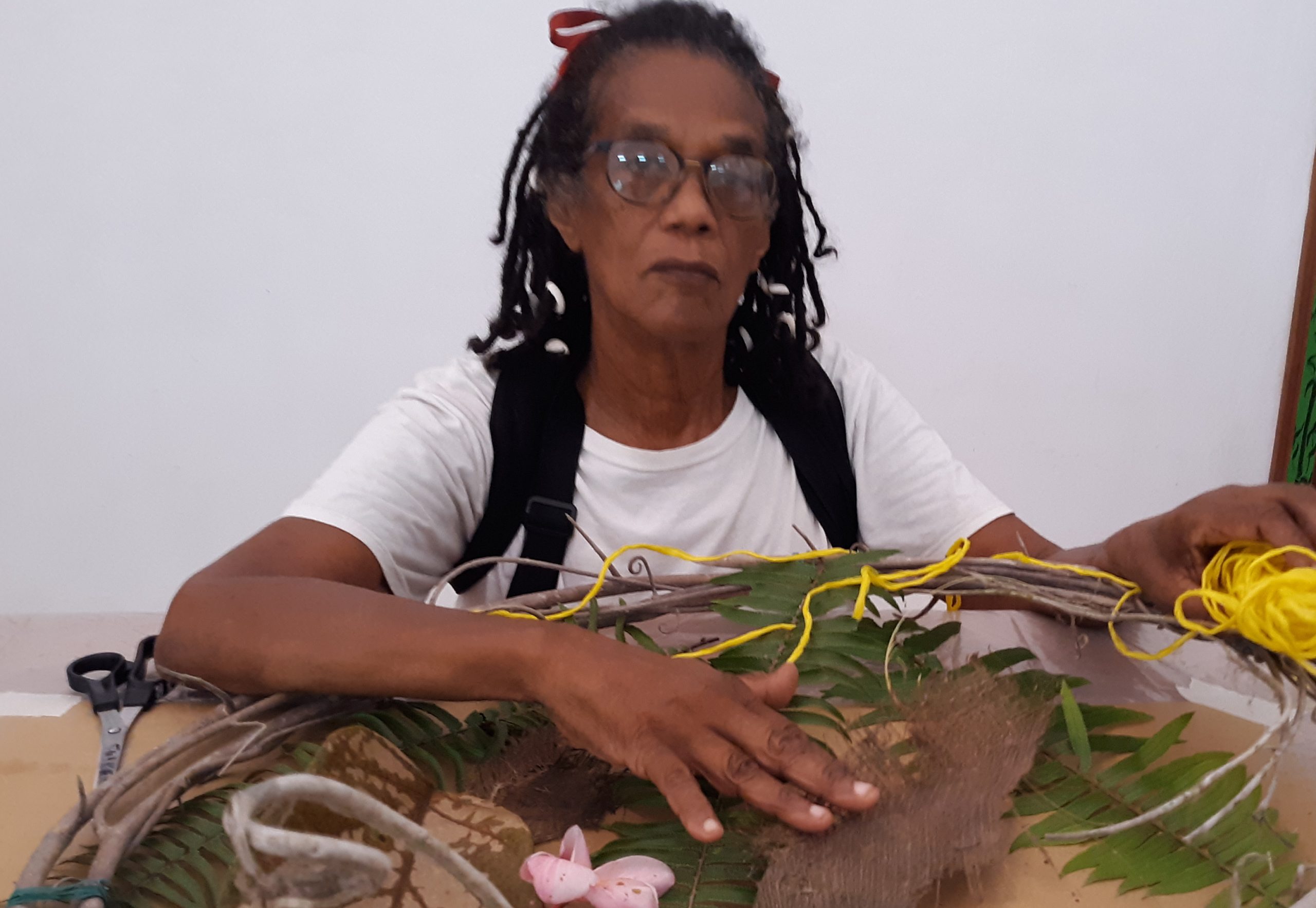 A photo graph of black woman artist Winsom Winsom working with textiles at a table.