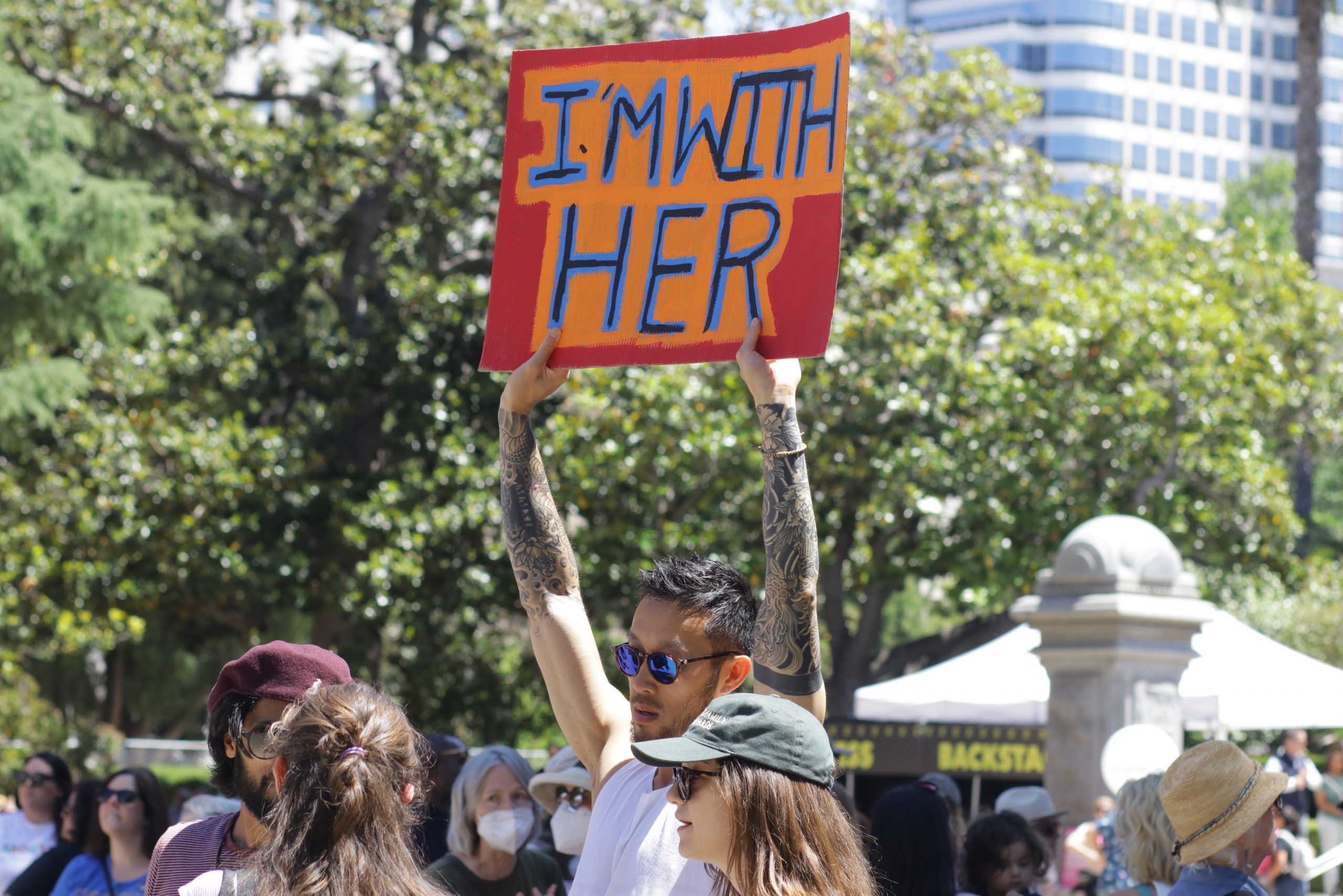 Photo of a man attending a pro abortion rights rally holding a sign saying "I'm with her"