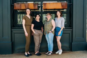 An photo of the change creates change team (four white women) standing in front of a store front.